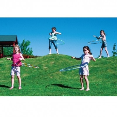 Crianças a brincar com aros coloridos num relvado verde sob céu azul