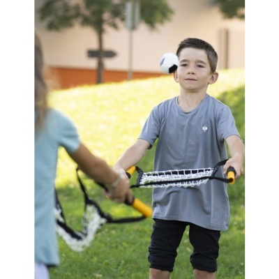 Criança a jogar com raquete de rede e bola ao ar livre na relva