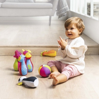 Bebé sentado no chão com brinquedos coloridos de tecido