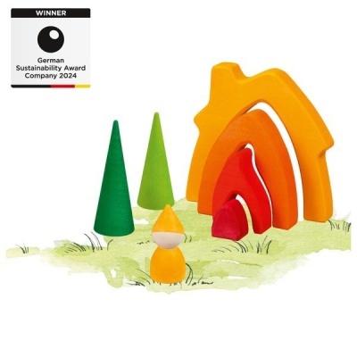 Brinquedos de madeira coloridos representando árvores, figura humana e arcos coloridos sobre superfície com relva pintada