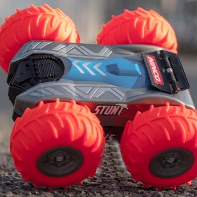 Brinquedo com rodas vermelhas e corpo cinza com azul em superfície de asfalto