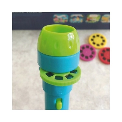 Microfone de brinquedo azul e verde com discos coloridos ao fundo