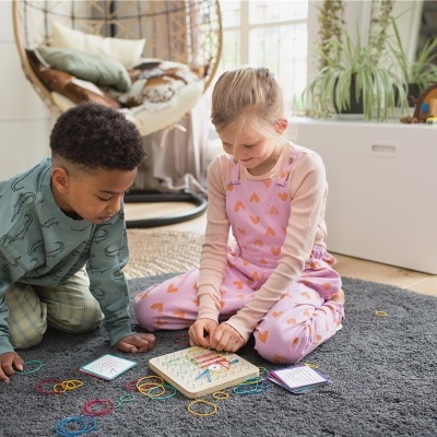 Crianças a jogar jogo educativo num tapete cinzento redondo