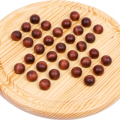 Tabuleiro redondo de madeira clara com bolas escuras para jogo