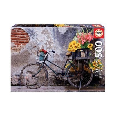 Caixa de puzzle com imagem de bicicleta preta e flores contra parede de cimento