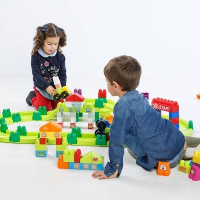 Crianças a brincar com blocos de construção coloridos no chão branco