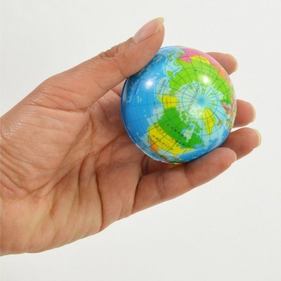 Globo terrestre pequeno colorido na mão sobre fundo branco