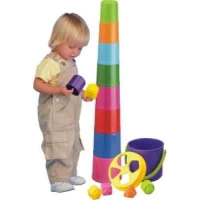 Criança a brincar com copos de empilhar coloridos e balde roxo
