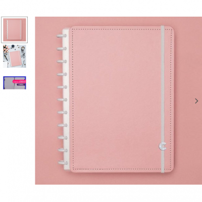 Caderno rosa com fecho elástico cinza e argolas brancas sobre fundo rosa