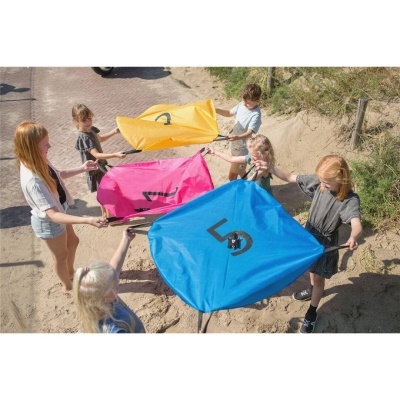 Cinco crianças seguram kites quadrados coloridos com números grandes em ambiente exterior