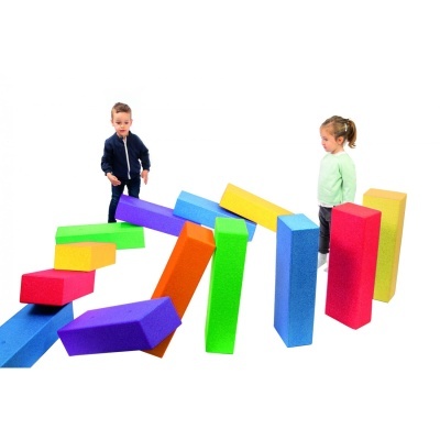 Crianças brincando com blocos de espuma coloridos em fundo branco.