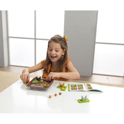 Jogo de tabuleiro infantil com peças de animais e manual sobre mesa branca com menina a jogar