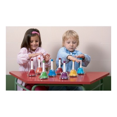 Crianças a tocar sinos coloridos numa secretária vermelha