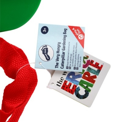 Cabo vermelho com etiquetas do produto 'The Very Hungry Caterpillar Gardening Bag' e nome 'ERIC CARLE' em fundo branco