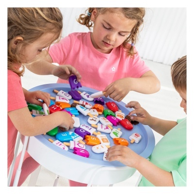 Crianças a brincar com blocos de gelados coloridos de plástico com letras e imagens numa bandeja azul