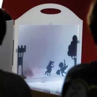 Ecrã de sombra portátil com figuras recortadas de castelo, lobo, cavaleiro e árvore.