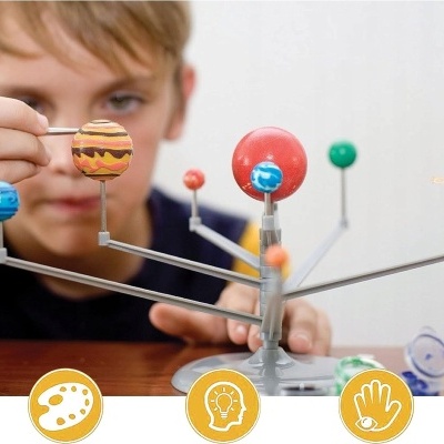 Modelo do sistema solar com planetas coloridos e menino ao fundo