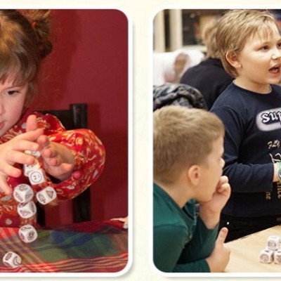 Crianças a jogar com dados de espuma letras pretas em ambiente interior