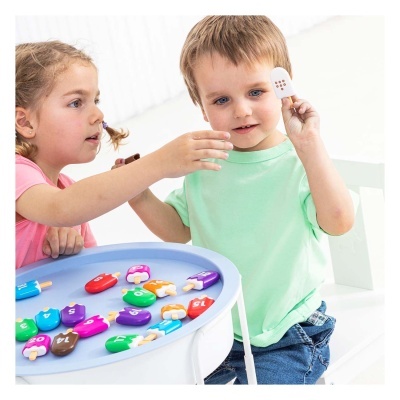 Crianças a brincar com peças de gelado coloridas numeradas em mesa