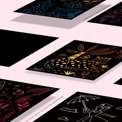 Cartões ilustrados multicolor em fundo preto dispostos sobre superfície clara