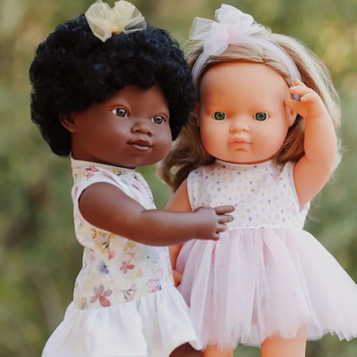 Duas bonecas infantis com vestidos floridos e laços no cabelo