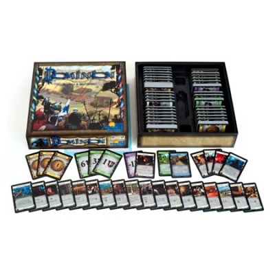 Jogo de tabuleiro Dominion com cartas organizadas e caixa aberta sobre fundo branco.