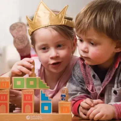 Crianças a brincar com blocos de madeira coloridos num tabuleiro de jogo