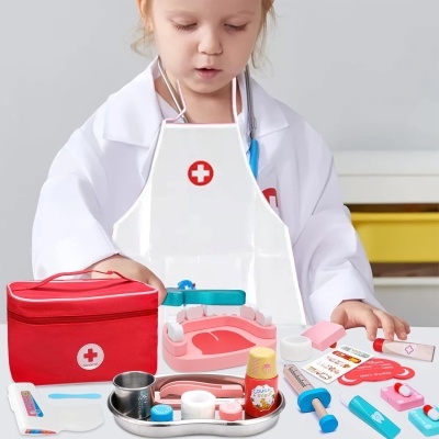 Criança com conjunto de brinquedo médico com acessórios coloridos e avental branco.