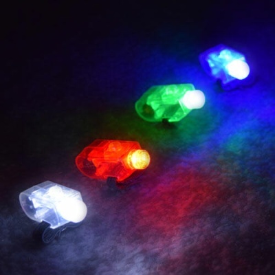 Quatro pequenas luzes LED coloridas iluminando uma superfície escura