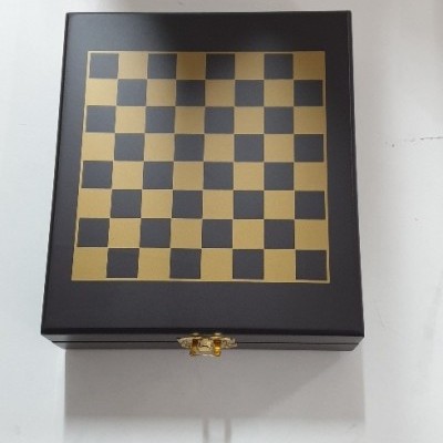 Caixa de xadrez preta e dourada com padrão quadriculado e fechadura dourada