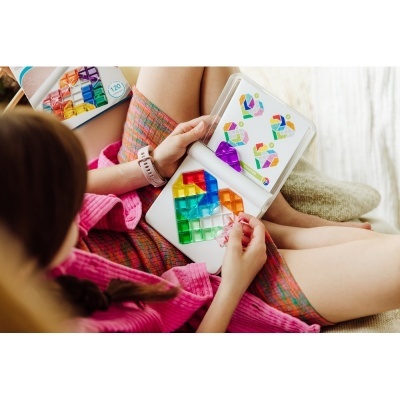 Jogo de peças de plástico coloridas num estojo branco com padrões geométricos.