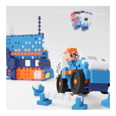 Brinquedo de construção em blocos coloridos com figura ao volante de veículo azul e branco
