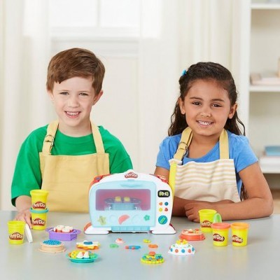 Crianças com aventais brincam com massa de modelar e forno de brinquedo Play-Doh.