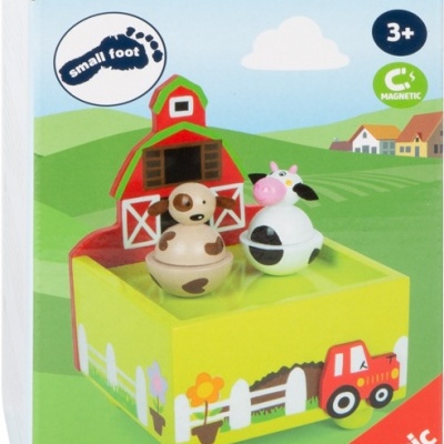 Caixa de música infantil temática de quinta em madeira com figuras magnéticas de vaca e cão à frente do celeiro vermelho.