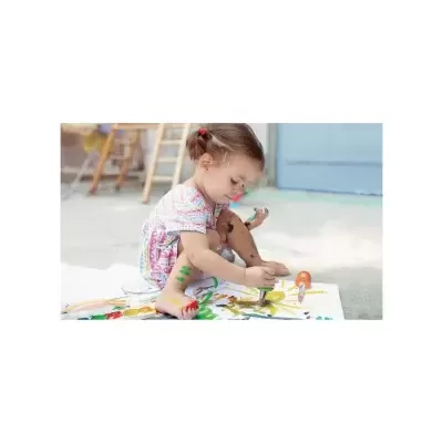 Menina pequena a pintar com pincel uma folha branca no chão