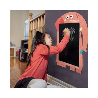 Criança a desenhar em quadro monstro preto com bordas vermelhas na parede