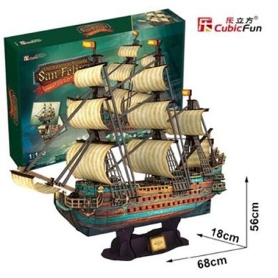 Modelo de navio em madeira com velas brancas e base preta ao lado da caixa do produto