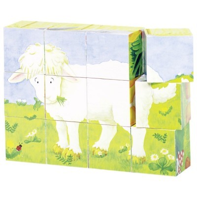 Blocos de madeira com desenho infantil de ovelha num campo verde