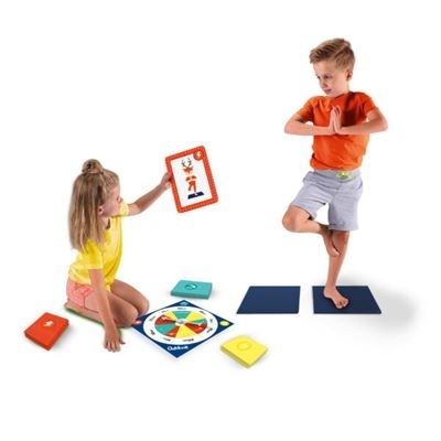 Crianças a jogar um jogo de tabuleiro educativo com cartas e tapetes coloridos