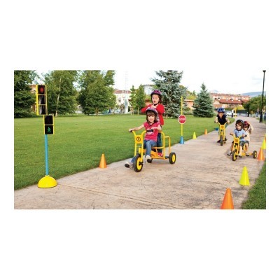 Crianças em triciclos amarelos numa pista ao ar livre com cones e sinais de trânsito.