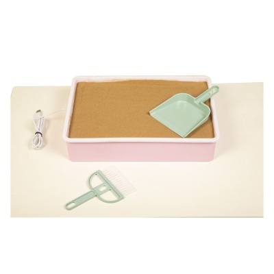 Caixa retangular rosa com areia castanha e utensílios verdes