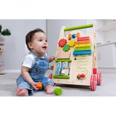 Criança pequena a brincar com carrinho de madeira colorido cheio de atividades educativas.