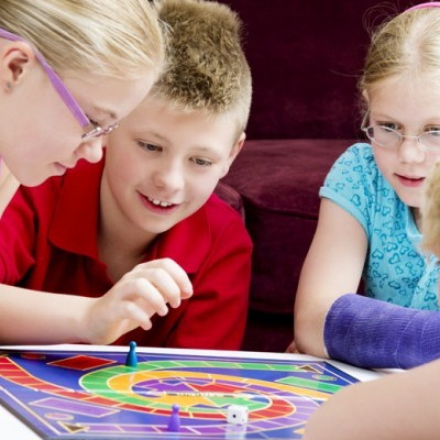 Crianças a jogar jogo de tabuleiro colorido