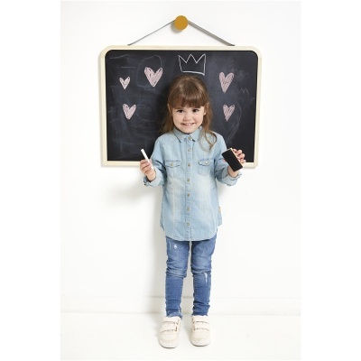 Menina em frente a quadro-negro com desenhos de corações e coroa em giz