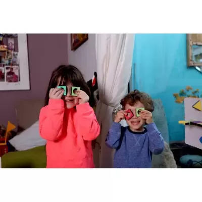 Crianças brincando com peças coloridas na sala