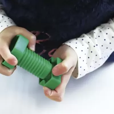 Criança segurando parafuso de brinquedo verde de plástico
