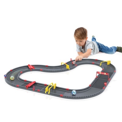 Pista de corrida preto com detalhes vermelhos e amarelos, menino a brincar com carrinhos