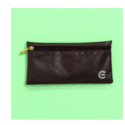 Estojo castanho escuro com fecho dourado sobre fundo verde