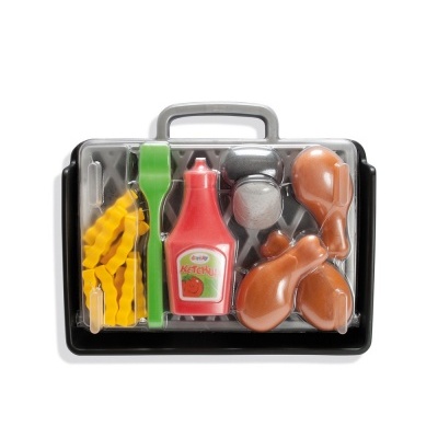 Conjunto de brinquedo com frango, batatas, garfo, faca e ketchup numa caixa preta.