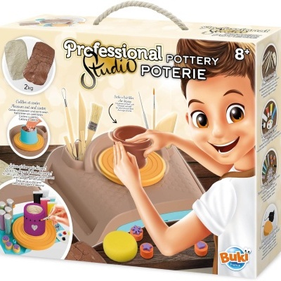 Kit de olaria profissional para crianças com barro, ferramentas e rodete amarelo numa embalagem de cartão com asa de corda.